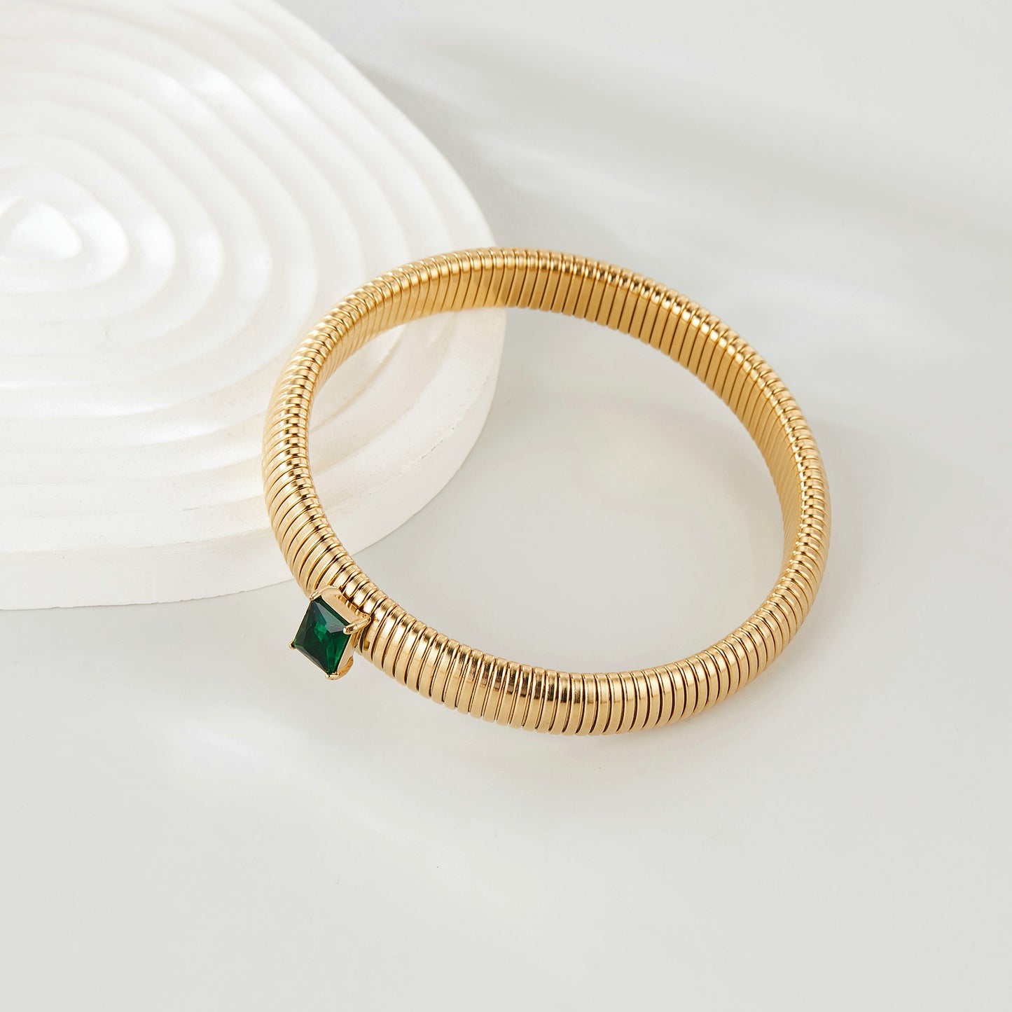 Pulsera elástica bañada en oro Mytys con diseño de cadena de serpiente acanalada y detalle de cristal esmeralda para un estilo minimalista moderno